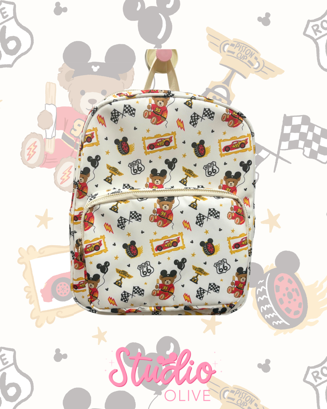 A white backpack featuring a colorful cartoon pattern of Mickey Mouse, cars, and racing motifs, displayed against a light background with a 'Studio Olive' logo at the bottom.